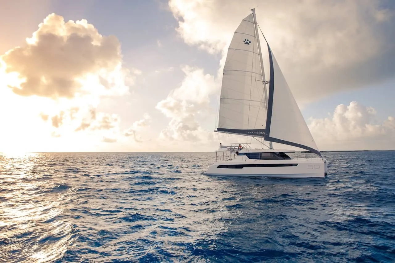 Honey Moon under full sail at sunset, Leopard 50 mainsail catching golden light